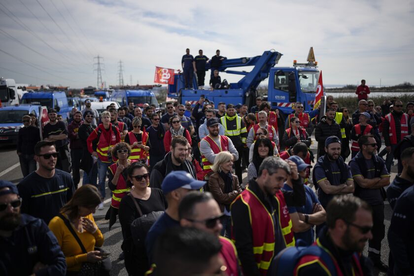 Oil workers on strike block the access to an oil depot in Foss-sur-Mer, southern France, Tuesday, March 21, 2023. The bill pushed through by President Emmanuel Macron without lawmakers' approval still faces a review by the Constitutional Council before it can be signed into law. Meanwhile, oil shipments in the country were disrupted amid strikes at several refineries in western and southern France. (AP Photo/Daniel Cole)