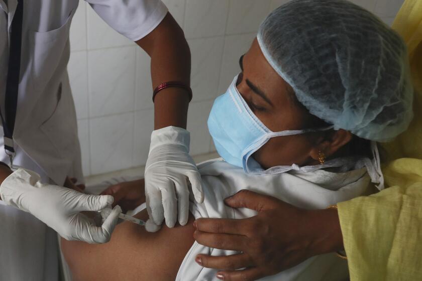 A health worker receives a COVID-19 vaccine at a government Hospital in Hyderabad, India, Monday, Jan. 18, 2021. India started inoculating health workers Saturday in what is likely the world's largest COVID-19 vaccination campaign, joining the ranks of wealthier nations where the effort is already well underway. (AP Photo/Mahesh Kumar A.)