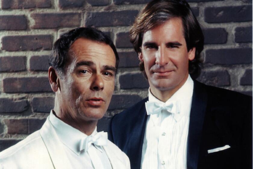 Two men in tuxedos, one holding a cigar