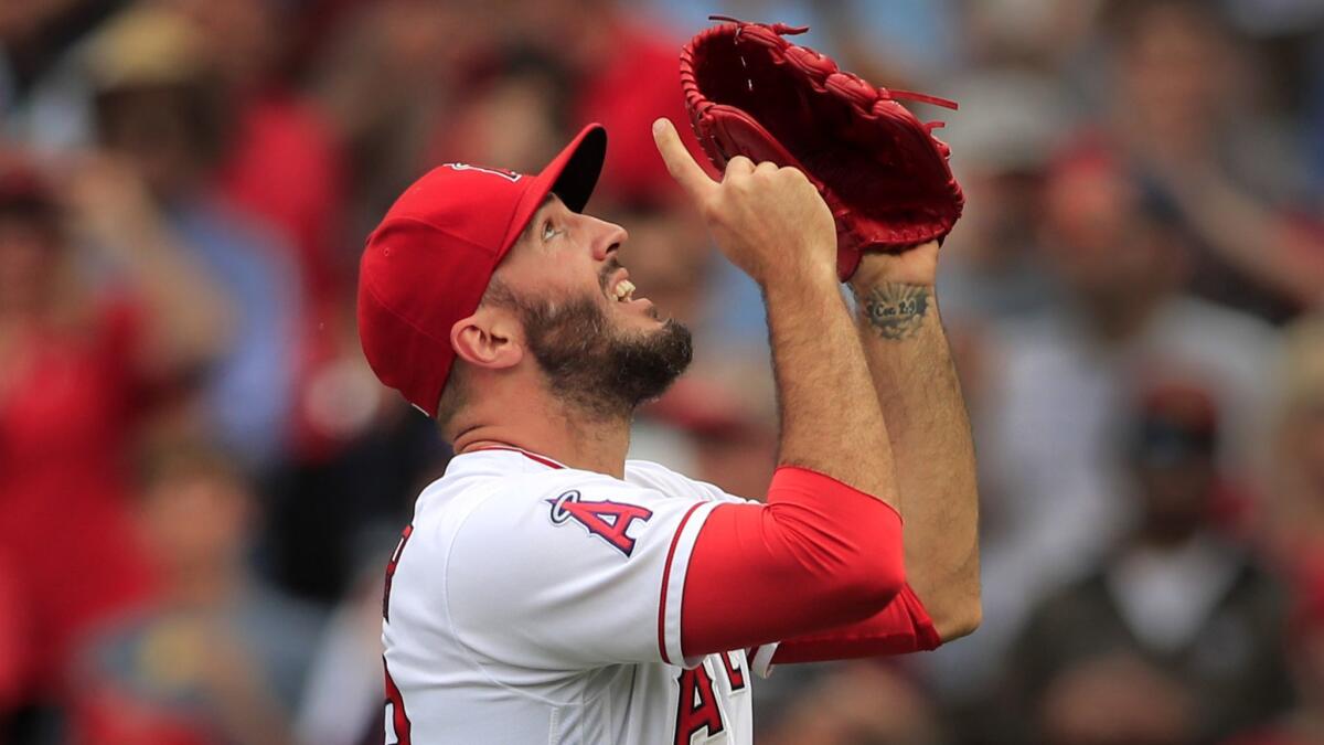 Angels relief pitcher Blake Parker points skyward as he celebrates getting the save against the Rays.