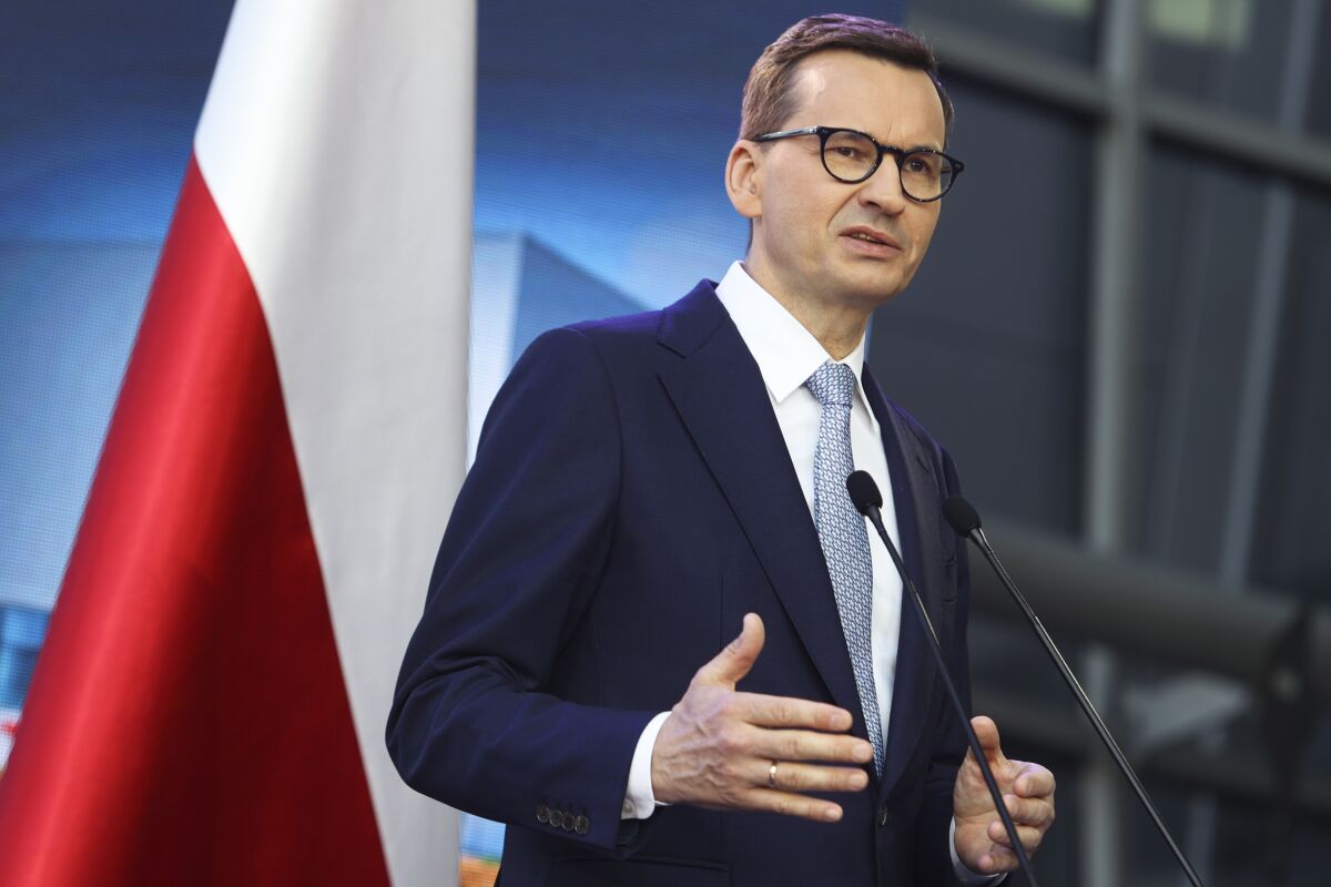 Poland's Prime Minister Mateusz Morawiecki briefs the media during a joint news conference with Polish President Andrzej Duda and European Commission President Ursula von der Leyen at the headquarters of Poland's Power Grid in Konstancin-Jeziorna, Poland, Thursday, June 2, 2022. The independence of Poland's courts is at the heart of a dispute with the European Union, which has withheld billions of euros in pandemic recovery funds. European Commission President Ursula von der Leyen meets Poland's leaders discuss the matter. (AP Photo/Michal Dyjuk)