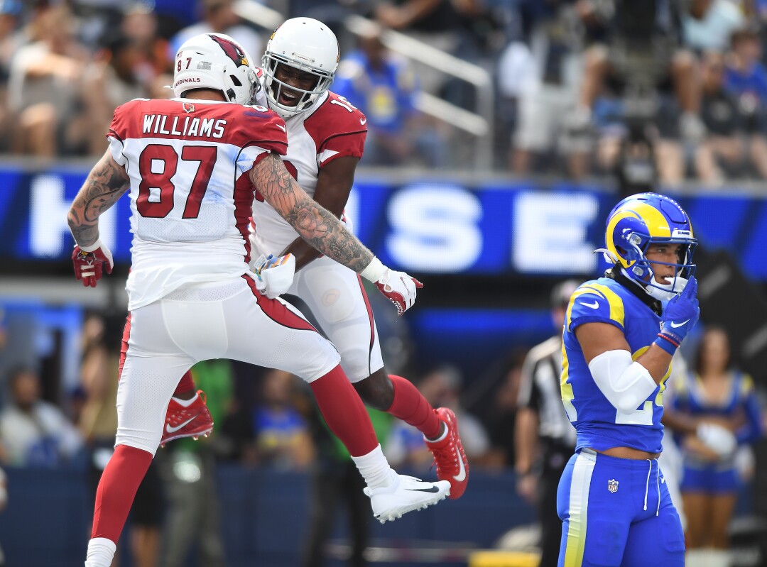 Cardinals tight end Maxx Williams celebrates his touchdown catch with A.J. Green as Rams safety Taylor Rapp walks away.
