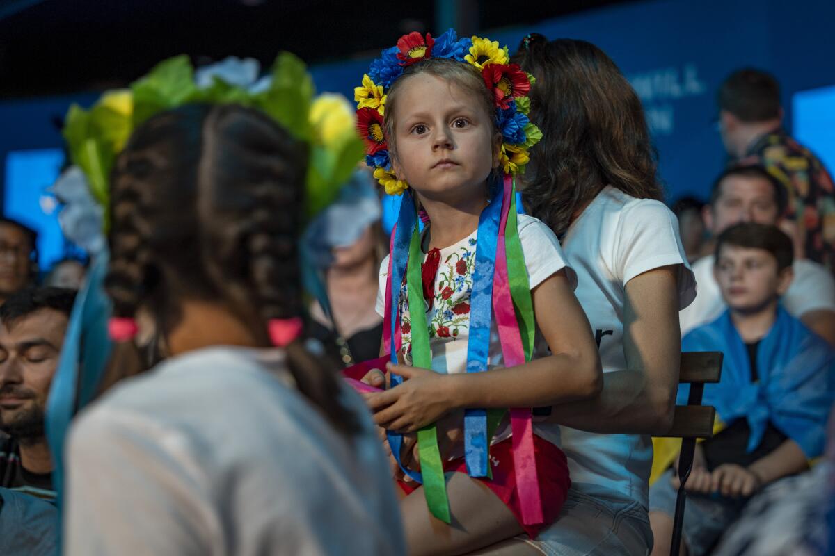 A girl with a traditional flower crown listens to a public talk at the Ukraine House.