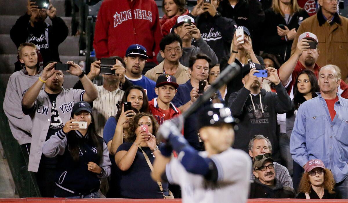 Fans take photos of Yankees second baseman Derek Jeter in the eighth inning during his final at-bat in the regular season at Angel Stadium on Wednesday night.