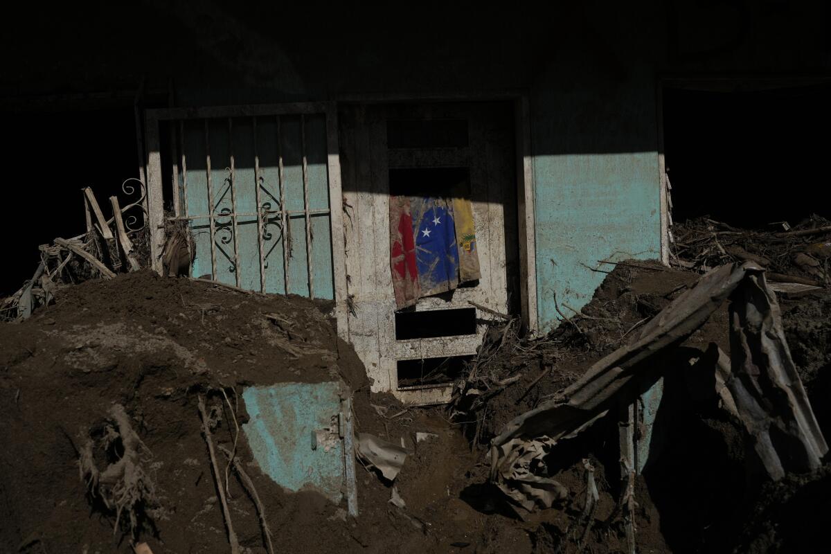 Una bandera venezolana cuelga en una casa llena de lodo
