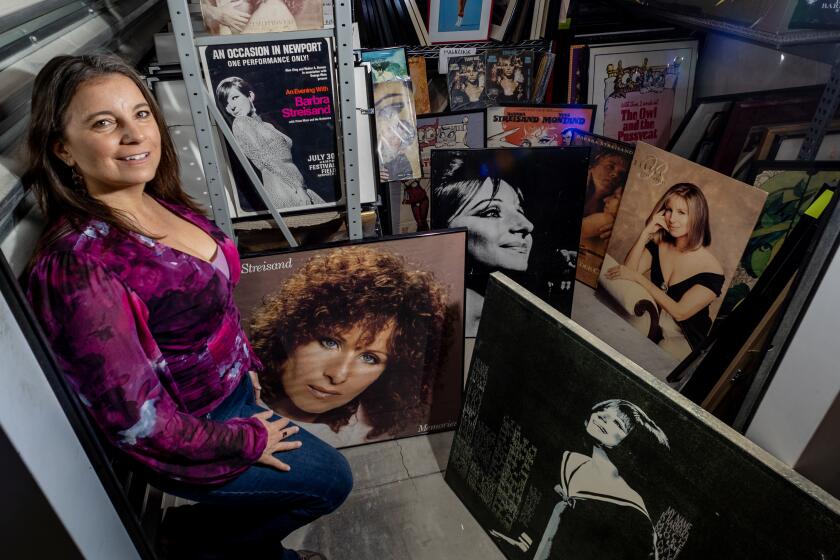 THOUSAND PLAMS, CA - NOVEMBER 29, 2023: Mara Papalas stands amidst just some of the hundreds of Barbra Streisand memorabilia inside a storage container on November 29, 2023 in Thousand Palms, California. Her father Louis Papalas bequeathed the largest Barbra Streisand collection in the world to his daughter after he died in March. (Gina Ferazzi / Los Angeles Times)