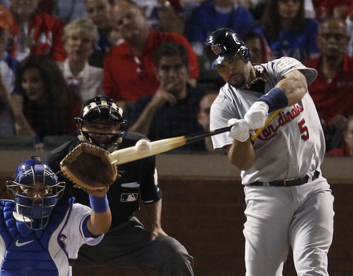 Cardinals first baseman Albert Pujols hits a three-run home run in Game 3 of the 2011 World Series against the Texas Rangers.