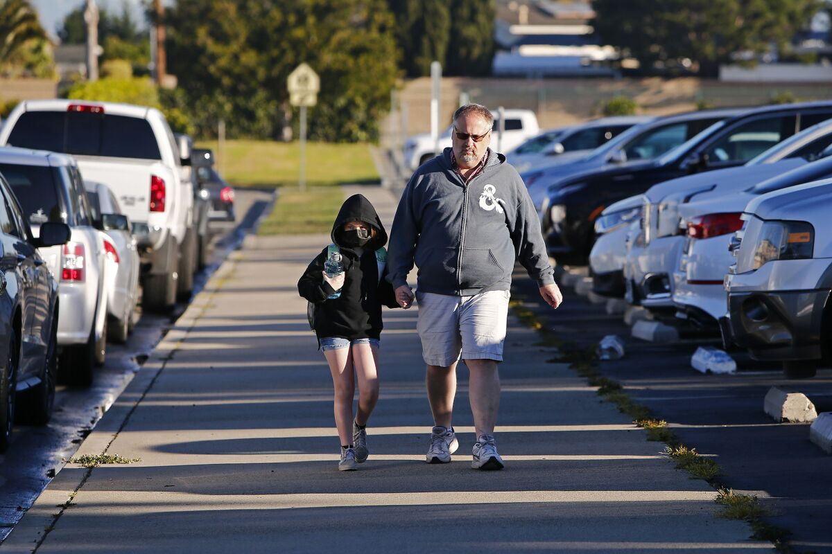 Colin Totman walks his daughter to class on Tuesday morning at Hope View Elementary in Huntington Beach.