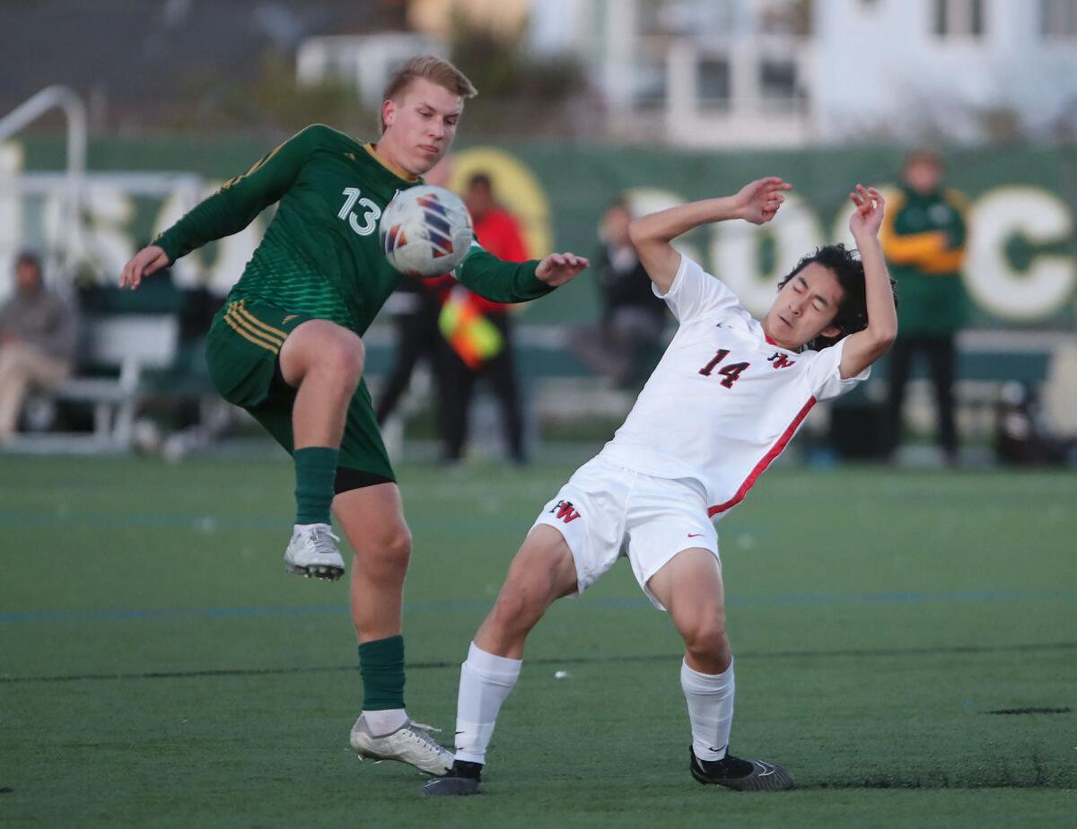 Edison's Evan Crownfield (13) moves the ball up field as Harvard-Westlake's Kevin Chen (14) defends.