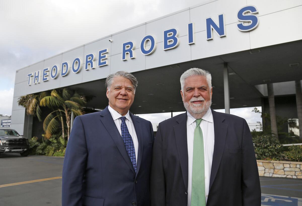 David and Jim Robins, from left, stand outside the Harbor Boulevard dealership that's been in Costa Mesa since 1966. 