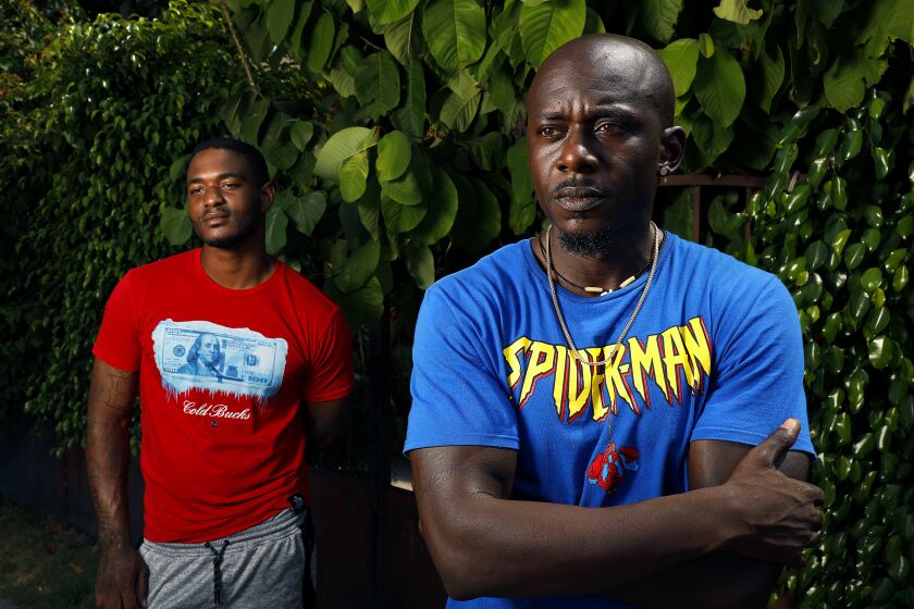 LOS ANGELES-AUGUST 24, 2020: Joshua McKinney, 26, left, and Eric Hunt, 41, are photographed at Joshua's grandmother's home in Los Angeles on Monday, August 24, 2020. The two are former inmate firefighters who want to go back to fighting fires, but can't because of legal barriers over their criminal records. (Christina House / Los Angeles Times)