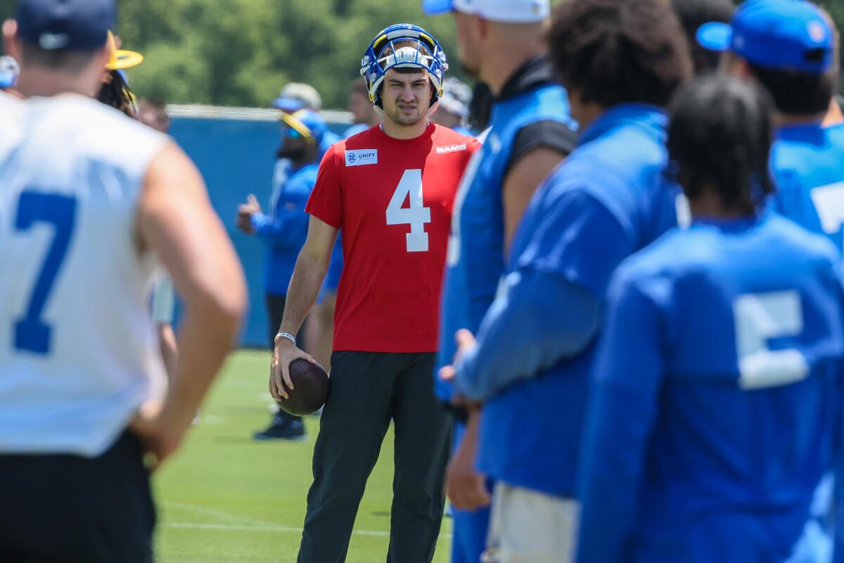 Rams quarterback Dresser Winn (4) holds a football as he watches practice.