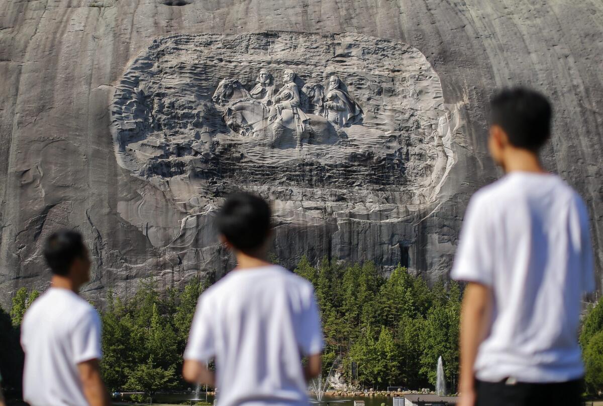 Visitors view the Confederate Memorial Carving this month, depicting Confederate President Jefferson Davis, left, Gen. Robert E. Lee and Thomas J. "Stonewall" Jackson on Stone Mountain in Georgia.