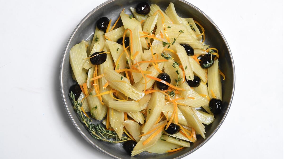 A dish of marinated cardoons with olives and orange.