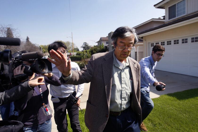 Journalists surround the man believed to be Bitcoin's creator, Dorian Satoshi Nakamoto, as he walks from his home to a car in Temple City.