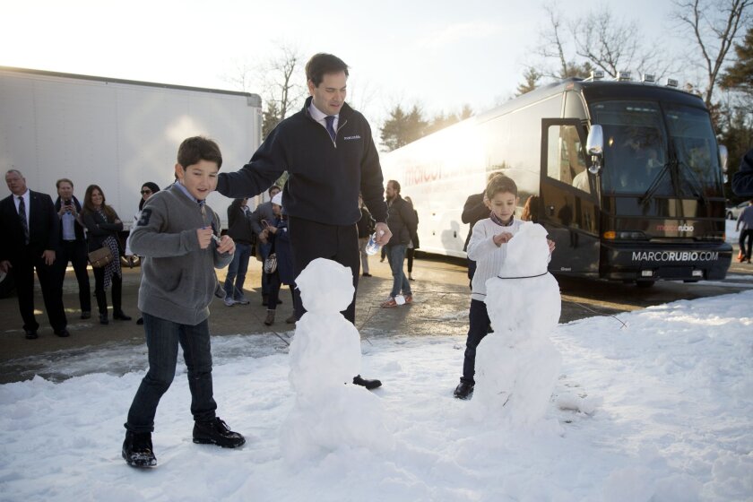 Sen. Marco Rubio with the snowmen that his sons Anthony, 10, left, and Dominick, 8, built on the campaign trail in Hudson, N.H.