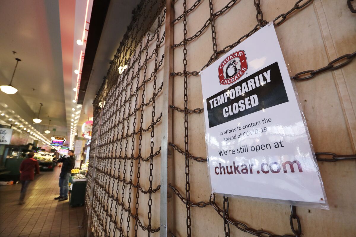 A sign explains the closure of a shop in the Pike Place Market Thursday in Seattle. 