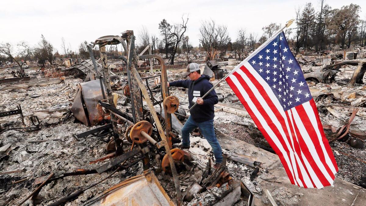 Jason Miller, 45, plants an American flag on the charred remains of his house in Coffey Park. He had lived in the Santa Rosa neighborhood for 23 years.