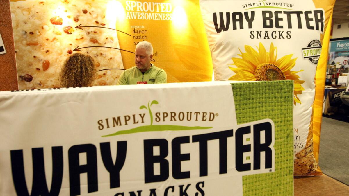 Jim Breen, founder of Way Better Snacks, right, talks with his sister Linda Carter surrounded by their display.