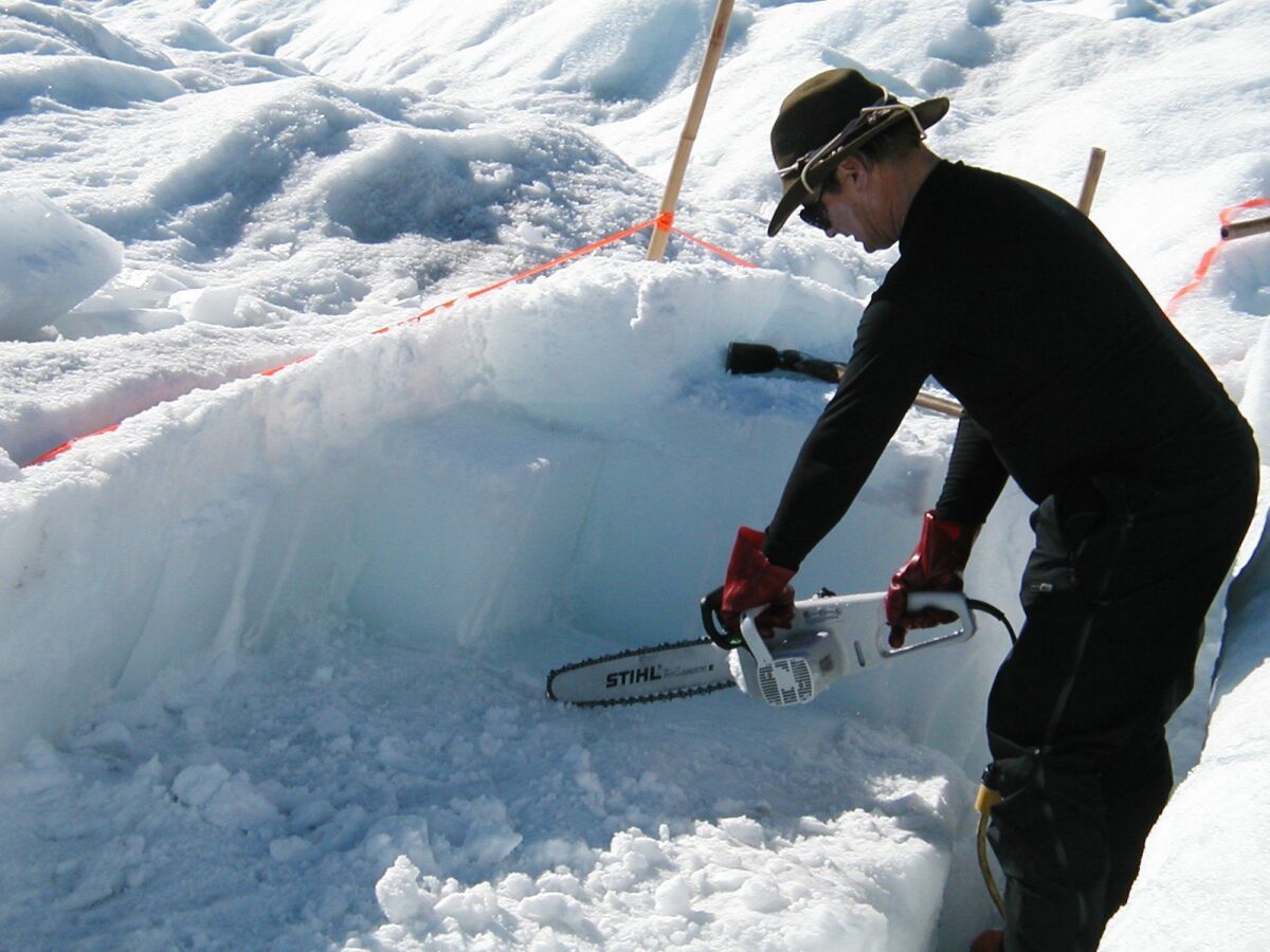 Jeff Severinghaus, a professor of geosicences at Scripps Institution Oceanography, cuts 12,000 year-old ice with a chainsaw in Pakitsoq in western Greenland.