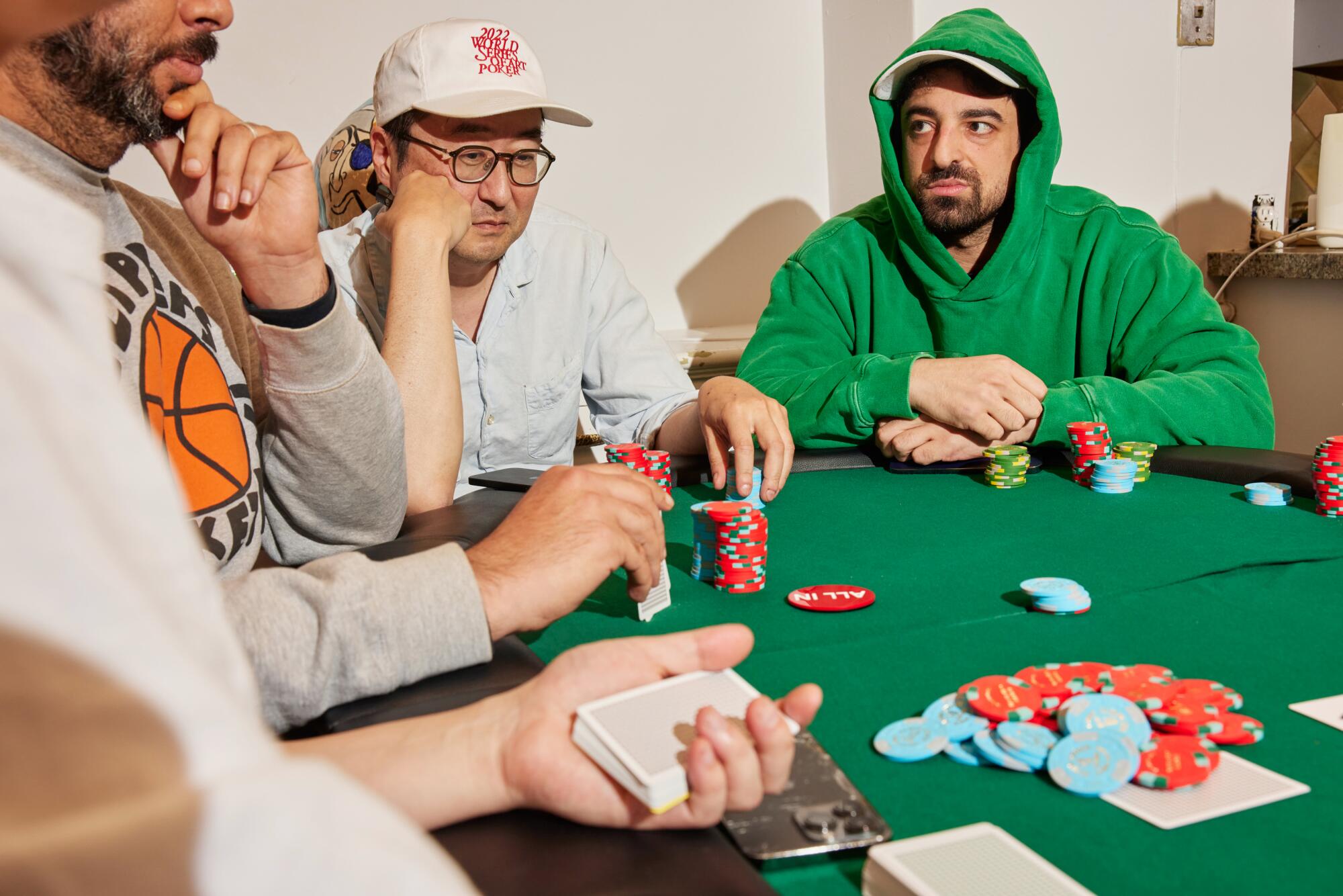 Poker players Grant Levy-Lucero, in a Clippers sweater, Eric Kim in a baseball hat and Jason Roussos in a green hoodie