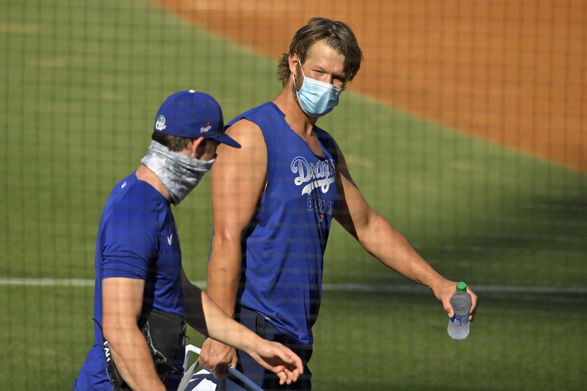 The Dodgers' Clayton Kershaw, right, talks with fellow pitcher Walker Buehler during summer training camp on  July 5, 2020.