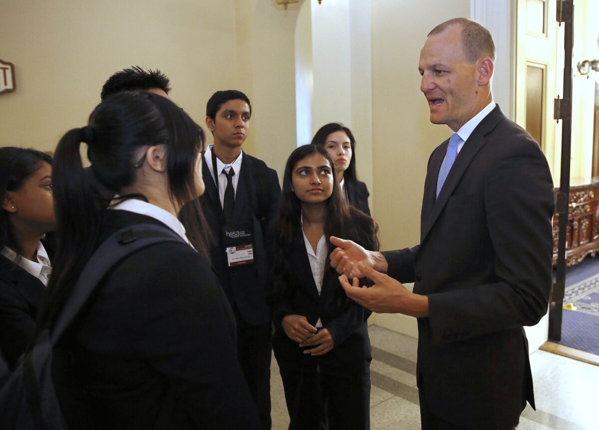 Assemblyman Kevin McCarty (D-Sacramento) talks with a group of high school students after a Thursday news conference concerning a package of bills dealing with the college admissions scandal.