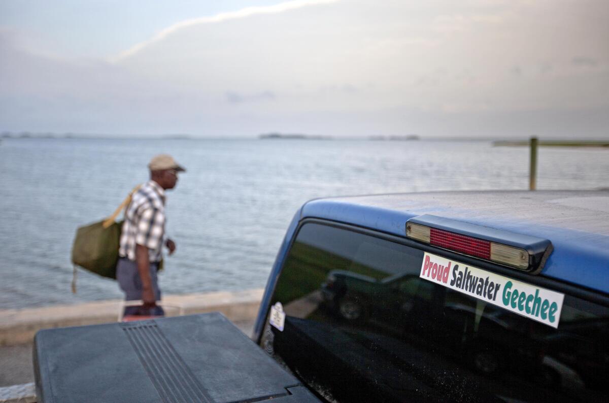 FILE - A sticker celebrating the Geechee heritage is seen on a pickup truck as passengers board a ferry to the mainland on Sapelo Island, Ga., June 9, 2013. An enclave of slave descendants on the Georgia coast have settled a federal lawsuit that claimed a lack of government services was eroding their island community, one of the few remaining Gullah-Geechee settlements on the Southeast U.S. coast. (AP Photo/David Goldman, File)