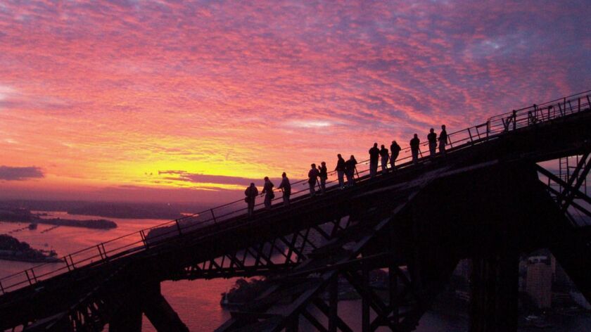 Climbers during the descent at sunset of BridgeClimb Sydney.