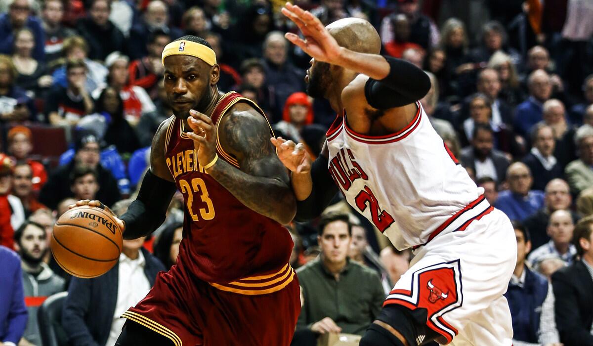 Cavaliers forward LeBron James tries to drive the baseline against Bulls forward Taj Gibson in the first half.