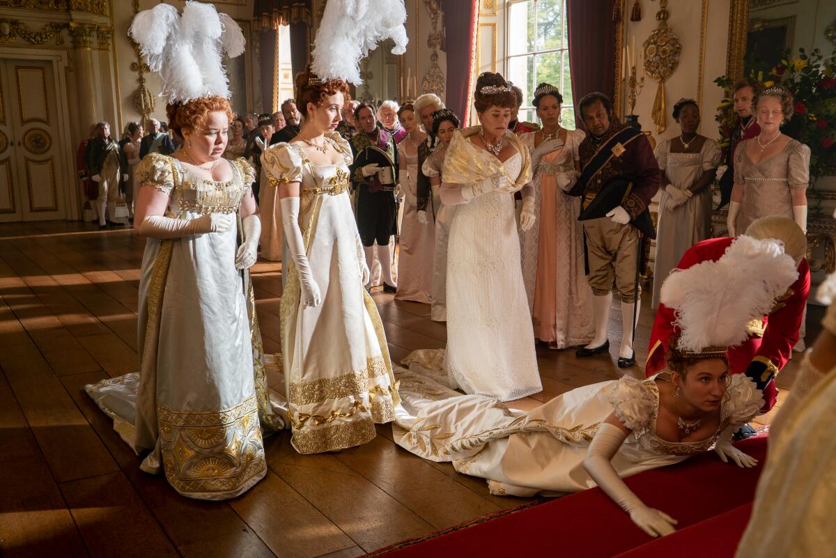 Nicola Coughlan, Harriet Cains and Bessie Carter stand over Polly Walker, who's on the floor, in "Bridgerton."