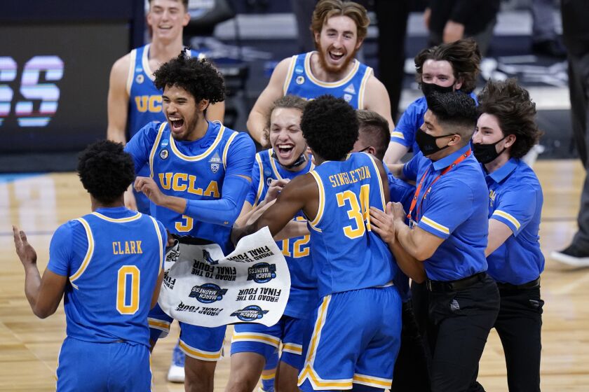 UCLA players celebrate after beating Alabama 88-78 in overtime of a Sweet 16 game in the NCAA.