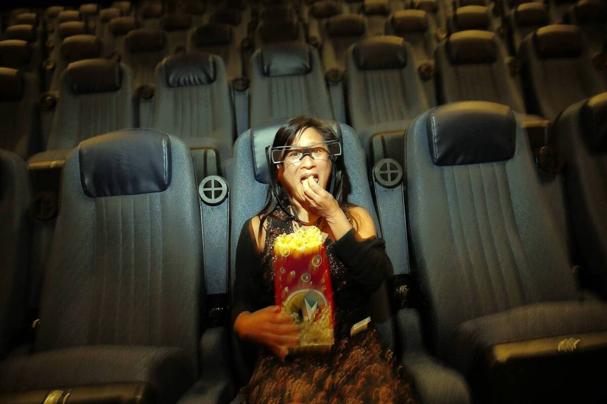 Lisa Yuan, who has profound hearing loss, is photographed wearing Sony's Entertainment Access Glasses on May 4, 2013. Having avoided all but foreign, subtitled movies for nearly 15 years, Yuan has enjoyed going to the movies more, utilizing the Sony glasses for their holographic technology, which projects caption text inside the glasses.