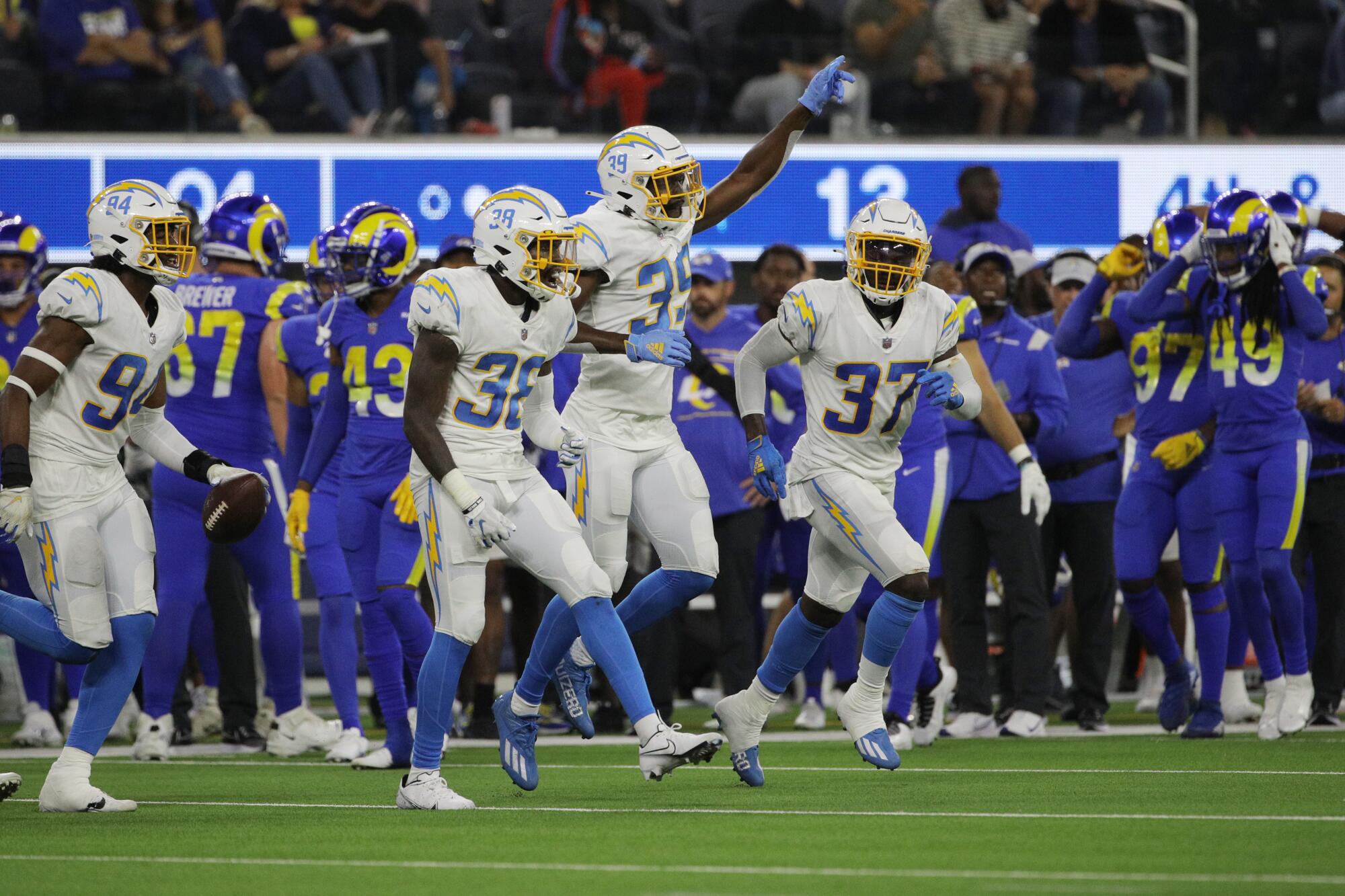 Chargers defensive back John Brannon celebrates with cornerback Donte Vaughn and defensive back Kemon Hall.