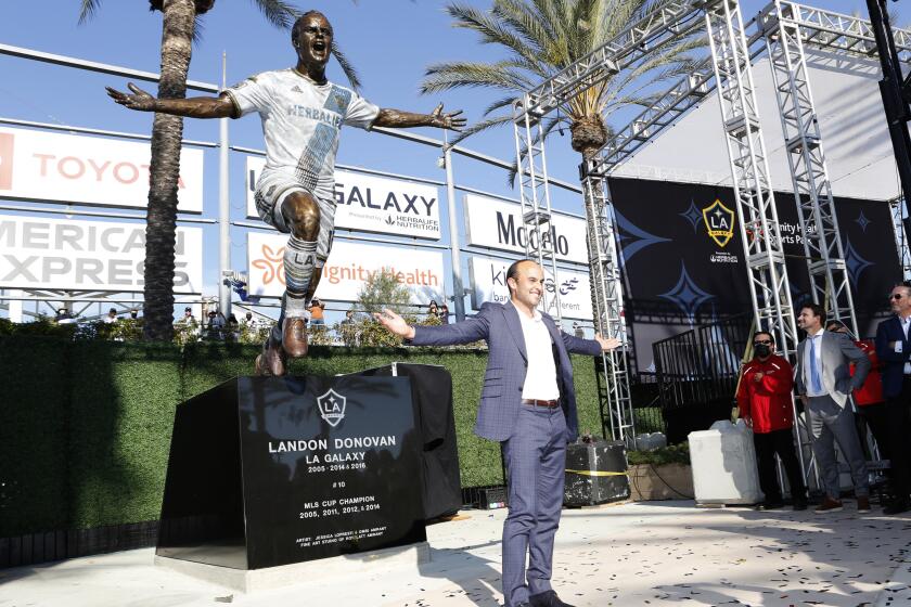 Former Galaxy player Landon Donovan poses with a statue in his likeness at Dignity Health Sports Park 