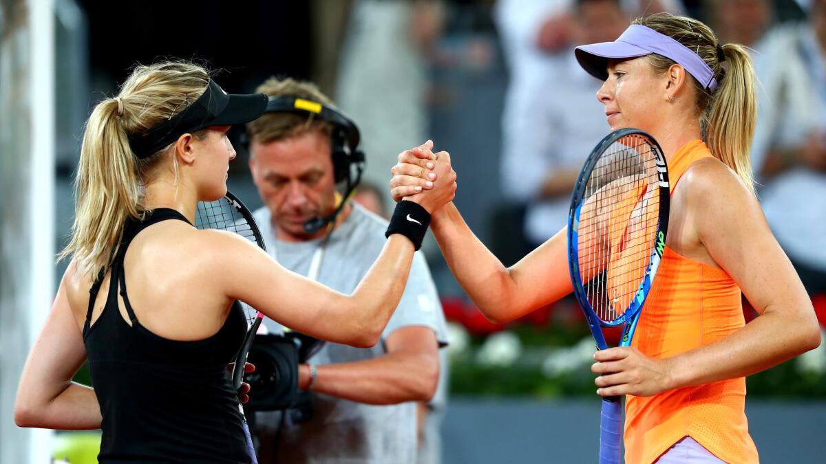 Eugenie Bouchard, left, and Maria Sharapova shake hands after their second-round match at the Madrid Open on Monday.