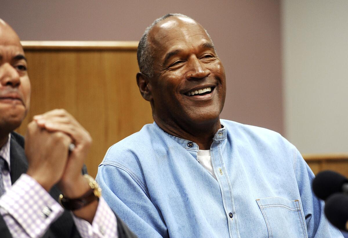 O.J. Simpson smiles in a courtroom.