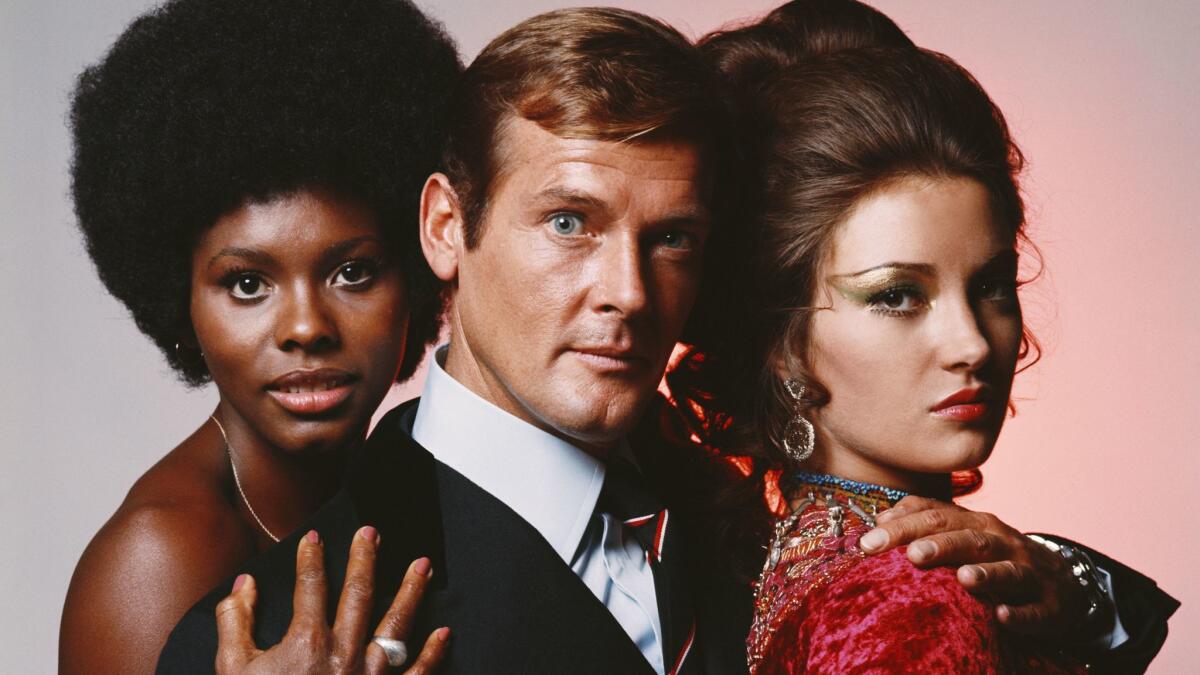 English actor Roger Moore in his role as James Bond in Guy Hamilton's film "Live and Let Die," circa 1973, with costars Gloria Hendry (left) and Jane Seymour.