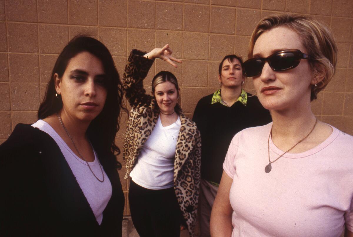 Four women in a rock band pose for a photo