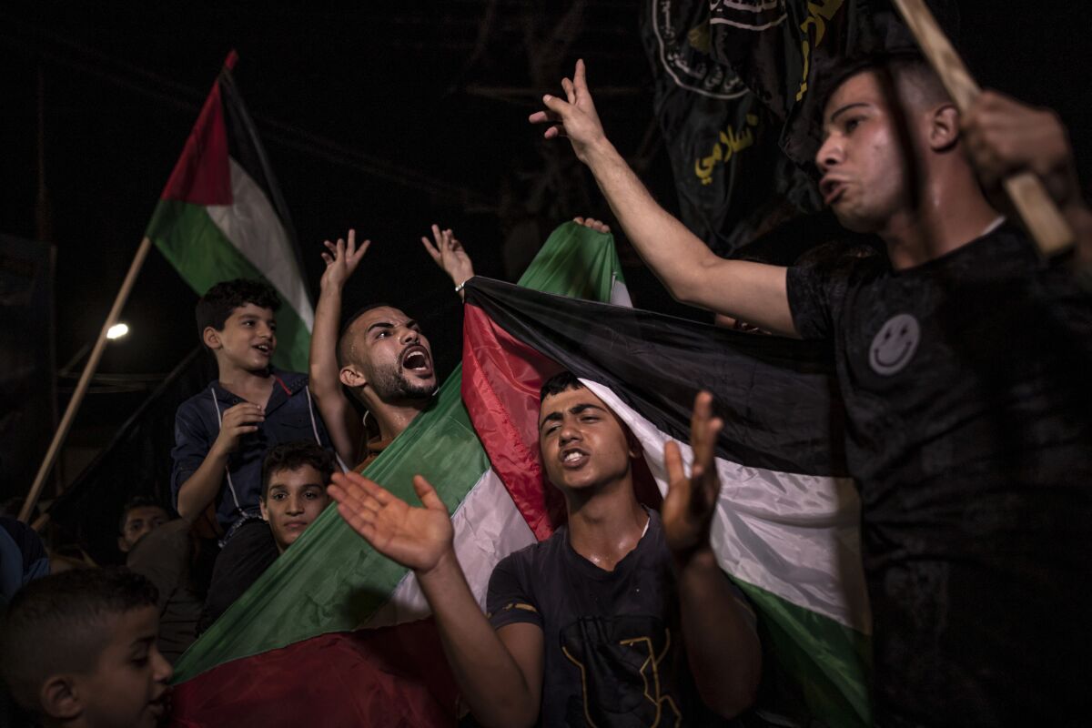 Palestinians celebrate the cease-fire agreement between Israel and Islamic Jihad Movement in Gaza City, early Monday, Aug. 8, 2022. A cease-fire deal to end nearly three days of fighting between Israel and Palestinian militants has held throughout the night, signaling the latest round of violence may have abated. (AP Photo/Fatima Shbair)