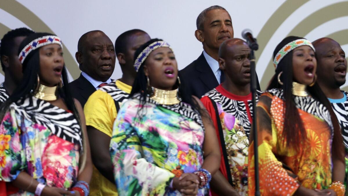 President Obama and South African President Cyril Ramaphosa, third from left, stand as members of the Soweto Gospel Choir sing the South African national anthem.