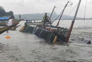 In this image from video provided by the Philippine Coast Guard, a man stands on a capsized passenger boat as they undergo rescue operations at Binangonan, Rizal province, east of Manila, Philippines on Thursday July 27, 2023. A Philippine passenger boat carrying dozens of people, including children, overturned Thursday after being lashed by strong wind in a town southeast of Manila and search and rescue efforts were underway, the Coast Guard said. (Philippine Coast Guard via AP)