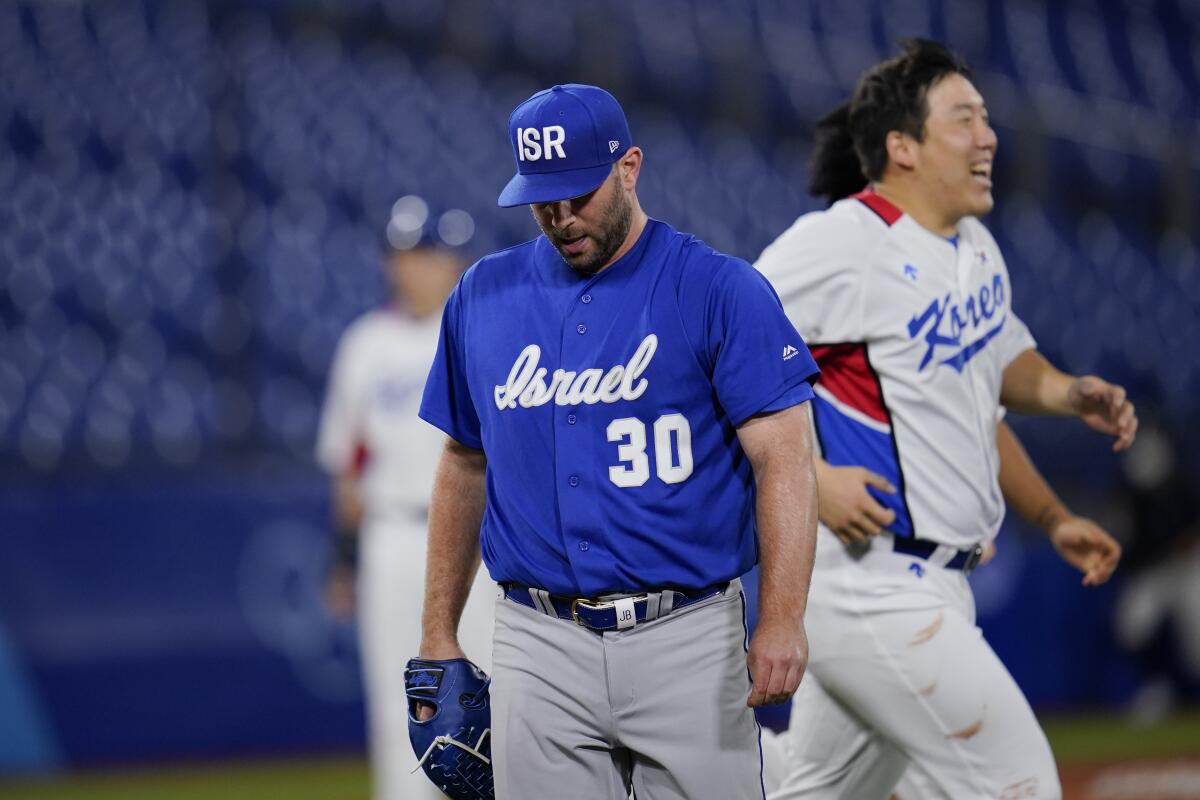 Israel's Jeremy Bleich walks off the field after hitting a South Korea batter with a pitch to bring home the winning run.