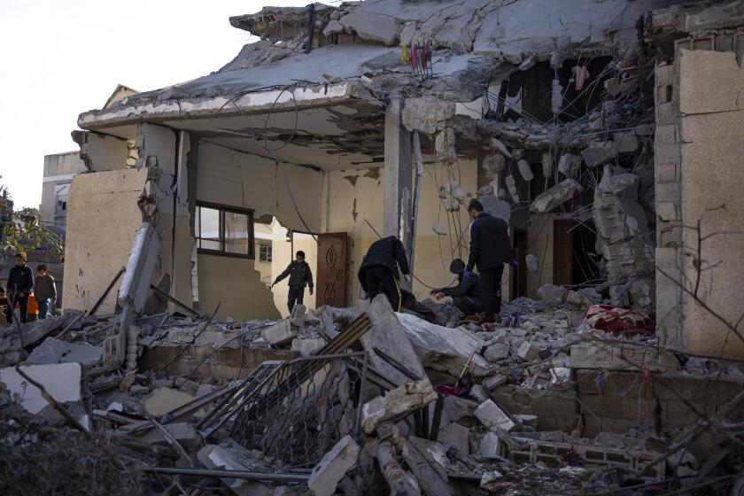 Palestinos revisan lo que quedó de una construcción tras un bombardeo israelí en Rafah, en la Franja de Gaza, el 21 de febrero de 2024. (AP Foto/Fatima Shbair)