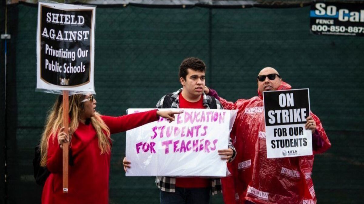 Gloria Perez-Stewart stands on the picket line Tuesday with her son, Aidan Villasenor Walker, and husband John Stewart. Aidan, who has autism, is a student at Eagle Rock Jr./Sr. High School.