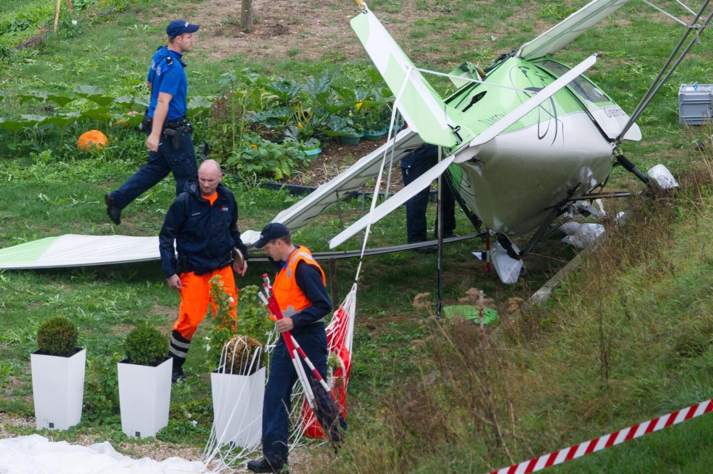 Swiss police officers inspect the wreckage of a plane involved in a collision with a second plane during an air show on Aug. 23, 2015, in Dittingen, Switzerland.