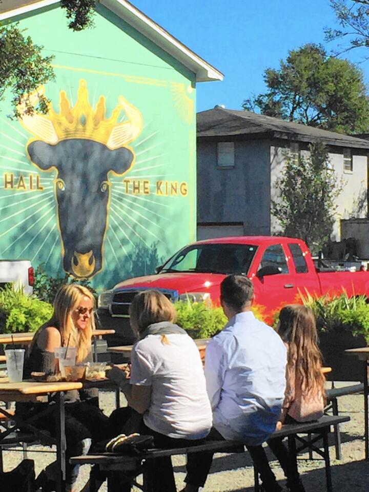 Diners dig into lunch at an outdoor table at Lewis Barbecue, where beef — not pork — is king.