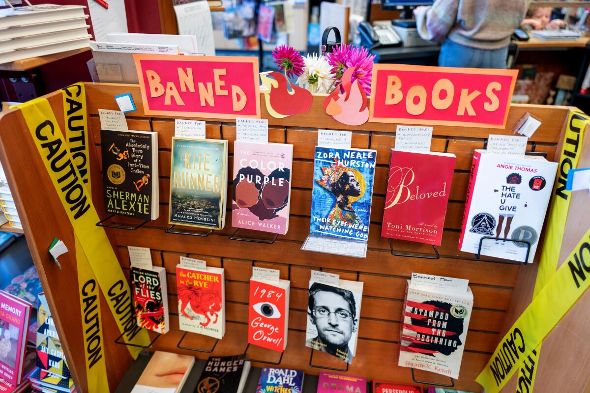 A display of books with caution tape on either side and a sign reading "Banned Books"