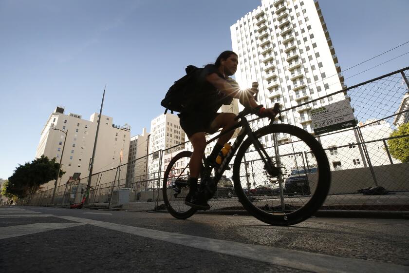 LOS ANGELES, CA - NOVEMBER 15: The sidewalk on Main Street near the 6th street intersection in downtown Los Angeles. The sidewalk has been fenced off between 5th and 7th Street, leaving a narrow walkway for pedestrians and wheelchairs and forcing some into the bike lane. For several months, an encampment blocked the sidewalk on the west side of Main but now the tents are gone. Councilman Kevin de Leon, who supports the new fencing while the street lights are fixed, said that part of Main Street had persistent violations of the Americans With Disabilities Act. Main Street at 6th on Monday, Nov. 15, 2021 in Los Angeles, CA. (Al Seib / Los Angeles Times).