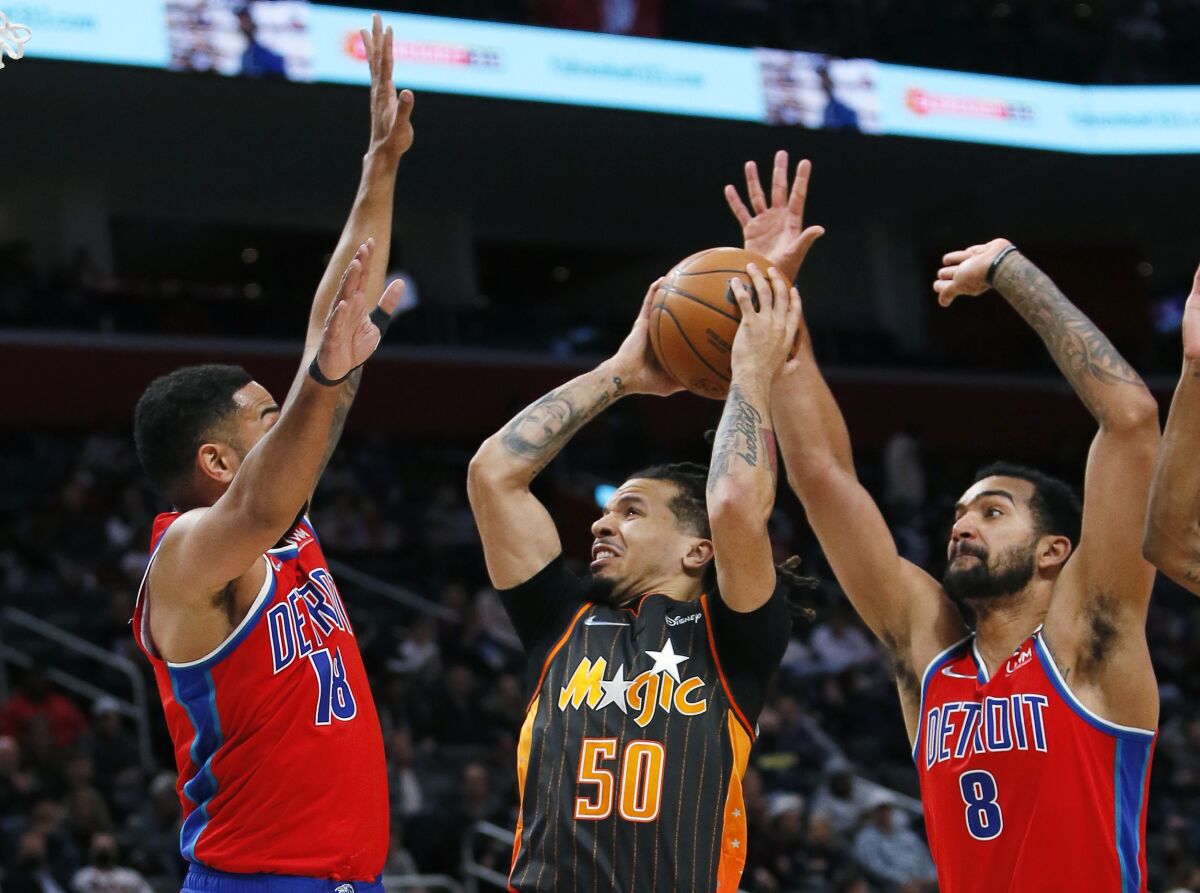 Orlando Magic guard Cole Anthony (50) goes to the basket against Detroit Pistons guard Cory Joseph (18) and forward Trey Lyles (8) during the first half of an NBA basketball game Saturday, Jan. 8, 2022, in Detroit. (AP Photo/Duane Burleson)
